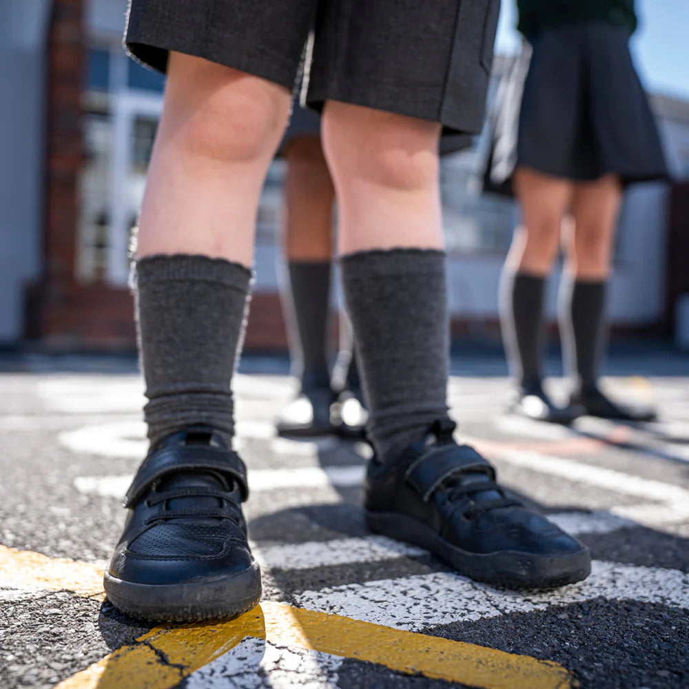 A kid wearing Vivobarefoot Primus Ludo School Kids Obsidian